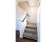Carpeted staircase with a wood railing, white risers and walls, and a window letting in natural light at 112 Edisto Crossing Ct, Ridgeville, SC 29472
