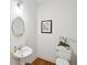 Bright half-bathroom featuring a pedestal sink, an oval mirror, and a floral arrangement at 1278 Deep Water Dr, Mount Pleasant, SC 29464
