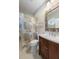 Updated bathroom with warm wood vanity, patterned shower curtain, and nautical theme for a stylish space at 1420 Polly Point Rd, Wadmalaw Island, SC 29487