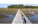 Picturesque boardwalk leading through the marsh, offering serene views and access to the waterfront at 1420 Polly Point Rd, Wadmalaw Island, SC 29487