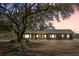 Charming brick home featuring a well-manicured lawn and a lovely facade with large shade tree in the front yard at 1420 Polly Point Rd, Wadmalaw Island, SC 29487