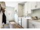 Functional laundry room with a washing machine, dryer, sink, and storage cabinets at 1420 Polly Point Rd, Wadmalaw Island, SC 29487