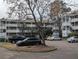 Multi-story building with exterior stairs, ample parking, and mature trees adding character and curb appeal at 1530 Fort Johnson Rd # 3F, Charleston, SC 29412
