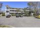 Three story apartment building with several parking spots and palm trees at 1530 Fort Johnson Rd # 3F, Charleston, SC 29412