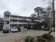 Exterior view of building with multiple levels, balconies, and parking, nestled among mature trees and landscaping at 1530 Fort Johnson Rd # 3F, Charleston, SC 29412