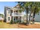 Charming two-story home featuring a double front porch, swing, and well-manicured lawn at 1532 Roustabout Way, Charleston, SC 29414