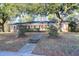 Charming brick home featuring a well-manicured lawn and beautiful mature trees at 1595 Dickens St, Charleston, SC 29407