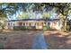 Charming brick home featuring a well-manicured lawn and beautiful mature trees at 1595 Dickens St, Charleston, SC 29407