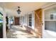 Inviting covered front porch with classic lantern lighting and brick exterior at 1595 Dickens St, Charleston, SC 29407