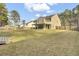 Spacious backyard shows the home's exterior, a covered porch, and a neighboring fence line at 1633 Pimlico Blvd, Moncks Corner, SC 29461