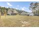 A large grass backyard shows the home, a covered porch, a fire pit, and a storage shed at 1633 Pimlico Blvd, Moncks Corner, SC 29461