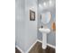 Charming powder room featuring a pedestal sink, oval mirror, and stylish lighting fixtures at 1633 Pimlico Blvd, Moncks Corner, SC 29461