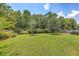 Spacious backyard featuring mature trees, a well-maintained lawn, and a wooden fence for added privacy at 1644 Fishbone Dr, Johns Island, SC 29455