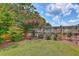 Well-manicured backyard featuring a lush lawn, colorful flowering trees, and a wooden fence at 1644 Fishbone Dr, Johns Island, SC 29455