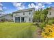 Exterior view of the home showcasing a well-maintained lawn, landscaping, and a screened-in porch at 1644 Fishbone Dr, Johns Island, SC 29455