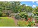 Lush backyard with vibrant flowerbeds, mature trees, and a well-maintained wooden fence at 1644 Fishbone Dr, Johns Island, SC 29455