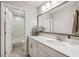 This bright bathroom features a large mirror, white cabinets, and tile floors at 1644 Fishbone Dr, Johns Island, SC 29455