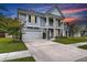 Stately two-story home with a welcoming front porch, lush landscaping, and a wide driveway for ample parking at 1644 Fishbone Dr, Johns Island, SC 29455