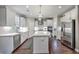 Bright kitchen features white cabinetry, stainless steel appliances, large island, and hardwood floors at 1644 Fishbone Dr, Johns Island, SC 29455