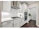 This kitchen features white cabinets, a gas stovetop, stainless steel range hood, and subway tile backsplash at 1644 Fishbone Dr, Johns Island, SC 29455