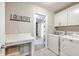 Bright laundry room featuring a countertop, storage cabinets, and modern washer and dryer at 1644 Fishbone Dr, Johns Island, SC 29455