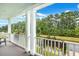 Relaxing porch view with white railing overlooking mature trees and landscaping for enhanced privacy at 1644 Fishbone Dr, Johns Island, SC 29455