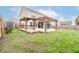 Large wooden deck with a pergola, leading to a screened-in porch, surrounded by a spacious lawn and privacy fence at 173 Cypress Forest Dr, Moncks Corner, SC 29461