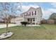 Lovely two-story home featuring a well-manicured lawn, a two-car garage, and decorative landscaping around the front entrance at 173 Cypress Forest Dr, Moncks Corner, SC 29461