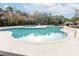Large community pool surrounded by a concrete deck with lounge chairs, tables, and a view of the trees and neighboring homes at 173 Cypress Forest Dr, Moncks Corner, SC 29461