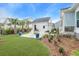 Charming backyard featuring a fire pit area, palm trees, and lush landscaping for relaxing outdoors at 1756 Timmons St, Mount Pleasant, SC 29466