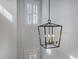 Modern black, cage-style pendant light fixture hanging near white wall and window with white shutters at 1756 Timmons St, Mount Pleasant, SC 29466