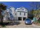 Exterior view showcasing the home's light colored siding and staircase at 18 Wills Way, Isle of Palms, SC 29451