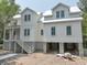 New construction exterior view of a modern white home with a metal roof and pilings at 18 Wills Way, Isle of Palms, SC 29451