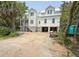 New construction of a coastal-style house featuring white siding, pilings, and a metal roof at 18 Wills Way, Isle of Palms, SC 29451