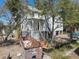 View of the home's exterior, featuring an elevated construction, and a dumpster filled with construction material at 18 Wills Way, Isle of Palms, SC 29451