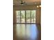 Bright living room with wood floors, ceiling fan, and sliding glass doors to the balcony at 1818 Orangeburg St, North Charleston, SC 29405