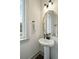 Stylish half bathroom boasting a pedestal sink, sleek fixtures, and an ornate gold-trimmed mirror at 1818 Orangeburg St, North Charleston, SC 29405