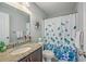 Well-lit bathroom with granite countertops, a large mirror, and blue and white floral shower curtains at 1880 Bacons Bridge Rd, Summerville, SC 29485