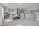Bright living room featuring neutral tones, plush carpeting, a comfortable sofa, and large windows for natural light at 1880 Bacons Bridge Rd, Summerville, SC 29485