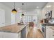 Bright, modern kitchen with stainless appliances, pendant lighting, granite counters and views to the open living space at 326 Ripple Park Dr, Summerville, SC 29486