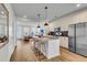 Modern, open kitchen with island, stainless appliances, pendant lighting and sight lines to living spaces and entry at 326 Ripple Park Dr, Summerville, SC 29486