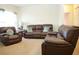 Comfortable living room featuring brown leather seating arrangements, bright natural lighting, and neutral color schemes at 3406 Mariners Way, Moncks Corner, SC 29461