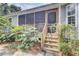 Back porch with wooden steps and railing, providing access to the house and surrounded by lush greenery at 3518 Gatetree Rd, Johns Island, SC 29455