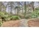 Lush backyard landscaping with stone pathway, mature trees and garden at 3518 Gatetree Rd, Johns Island, SC 29455