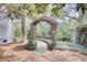A whimsical backyard garden with metal archway and a winding stone path at 3518 Gatetree Rd, Johns Island, SC 29455