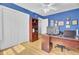 Bright office featuring hardwood floors, blue walls, a built-in bookshelf, and a spacious wooden desk at 3518 Gatetree Rd, Johns Island, SC 29455