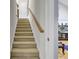 Carpeted staircase leading to the second floor, with wooden banister and a glimpse of the living room at 3518 Gatetree Rd, Johns Island, SC 29455