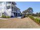 A spacious backyard features a lush lawn, a charming waterfront view, and the home's elegant architecture at 4176 Victory Pointe Dr, Mount Pleasant, SC 29466