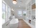 Well-lit bathroom with a soaking tub, natural light, and custom shelving at 4176 Victory Pointe Dr, Mount Pleasant, SC 29466
