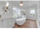 Spacious bathroom with white cabinetry, freestanding tub, and natural light from large windows at 4176 Victory Pointe Dr, Mount Pleasant, SC 29466
